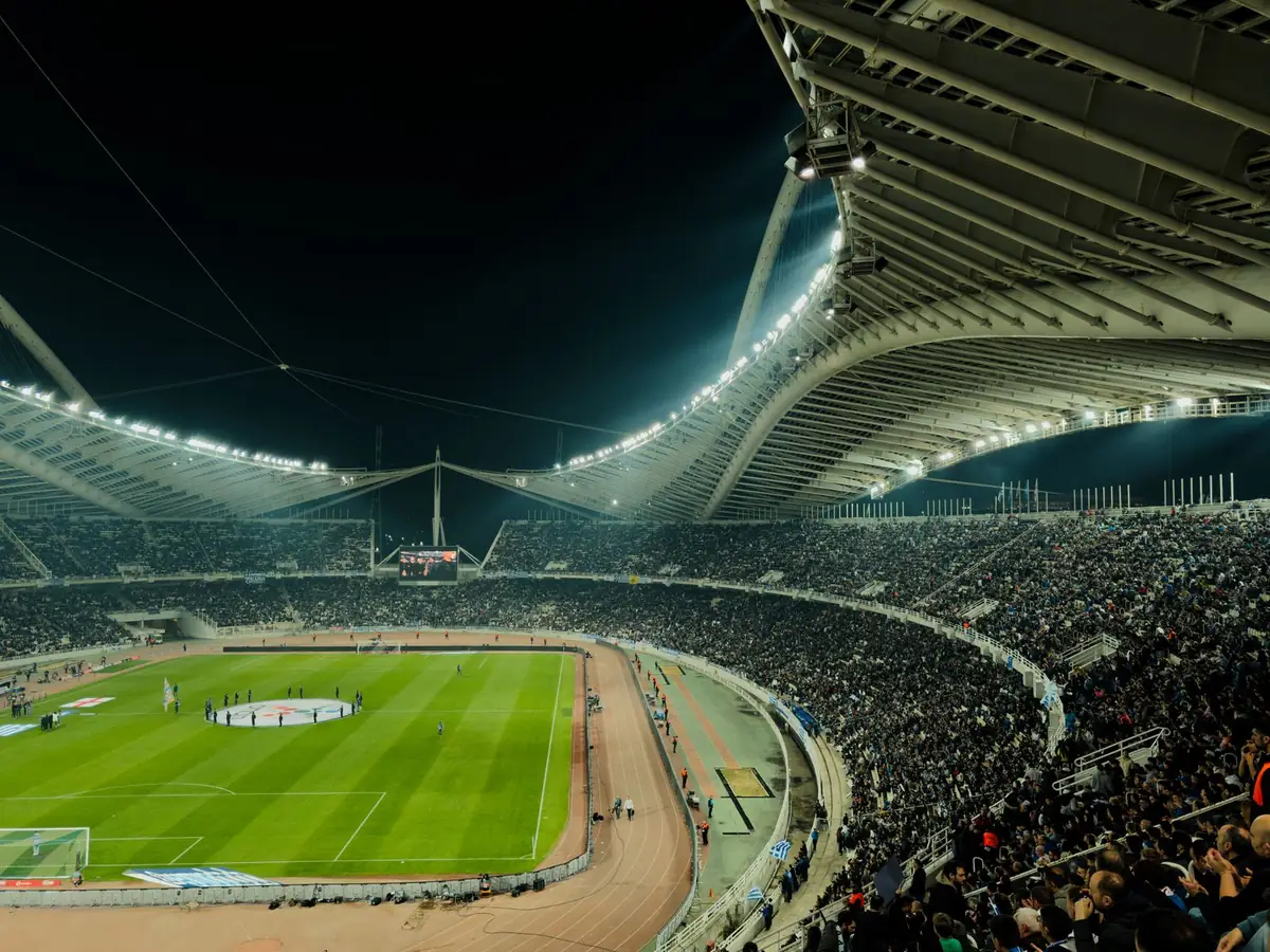 Tribun stadion sepak bola penuh penonton di malam hari