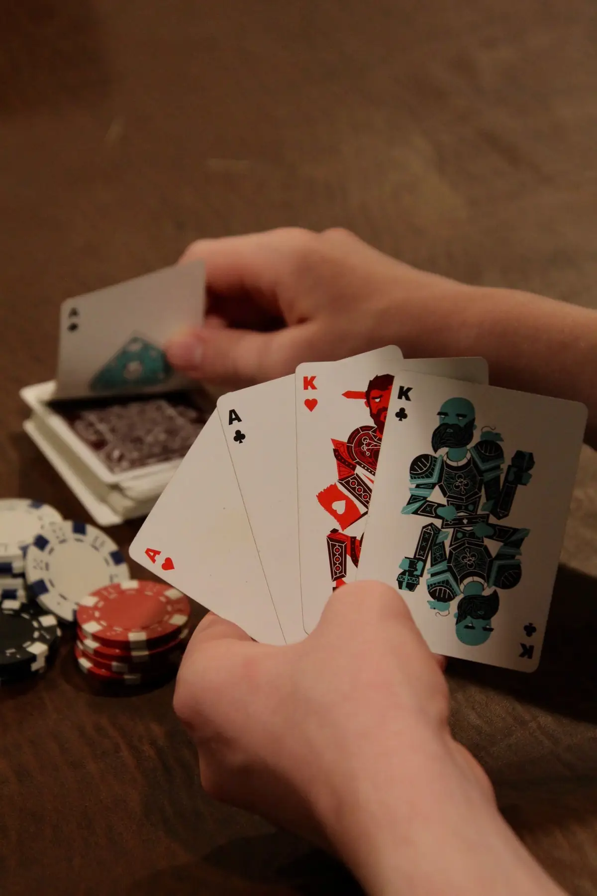 Tangan memegang kartu as dan raja dengan chip poker