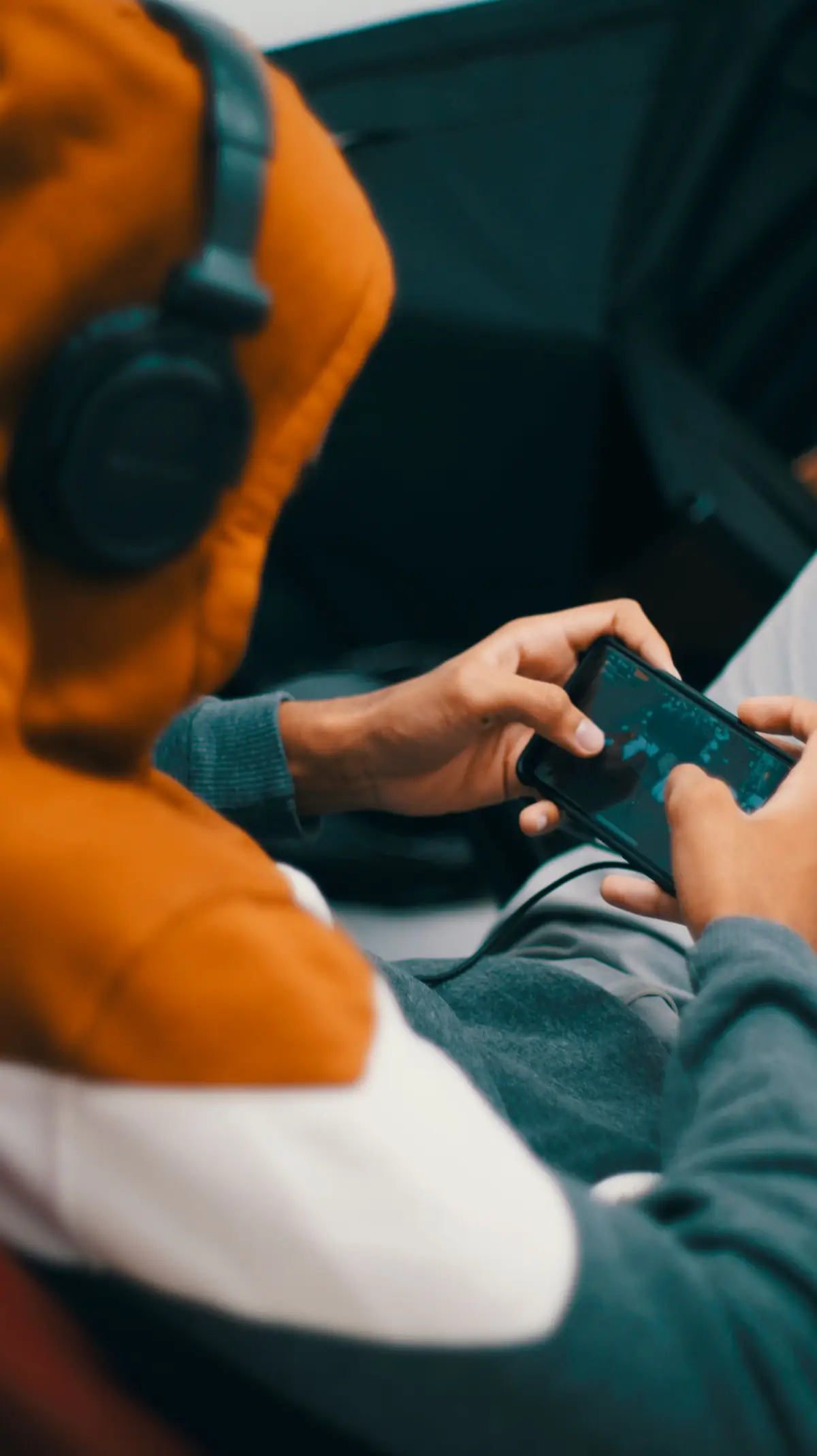 Pemain muda menggunakan ponsel dengan headset