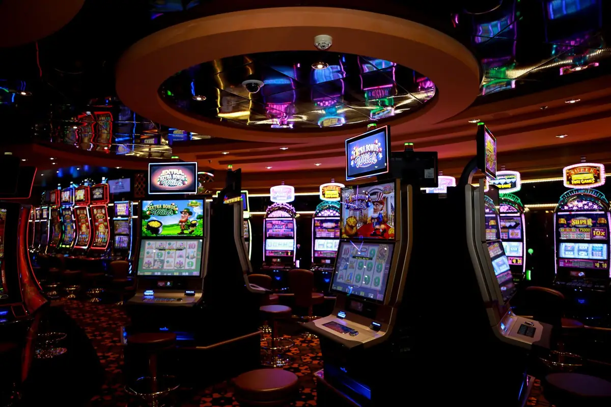 Barisan mesin slot warna-warni di lantai kasino